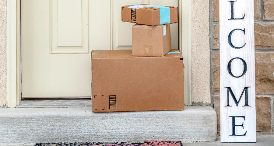 Packages on the doorstep of a home with a welcome sign in Milwaukee